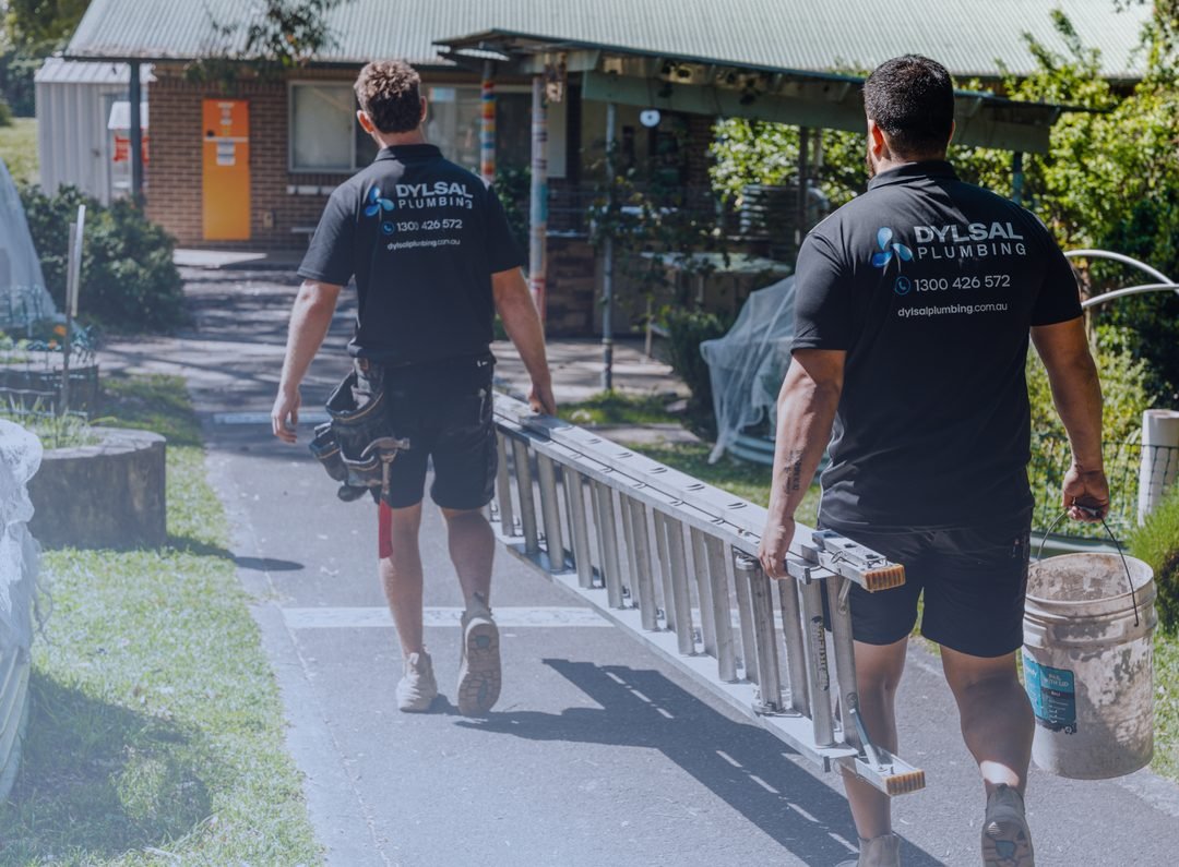 DYLSAL plumbers walking with ladder and tools to a job site
